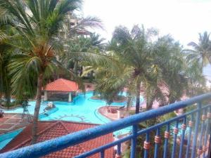 a view of a swimming pool with palm trees at New Renovated 2 Rooms Luxury Suites Anyer in Anyer