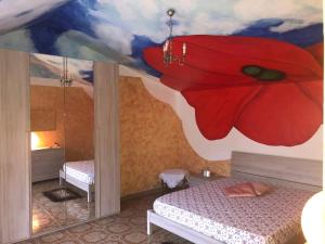 a room with two beds and a red flower painted on the ceiling at Bed and Breakfast IL CAVALIERE in Pozzilli