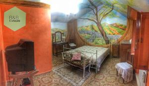 a bedroom with a painting on the wall and a tv at Bed and Breakfast IL CAVALIERE in Pozzilli