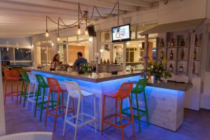 a bar with colorful bar stools in a restaurant at Evelin Hotel in Platanes