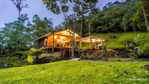 uma casa numa colina com luzes acesas em Mei Tai Cacao Lodge em Bijagua