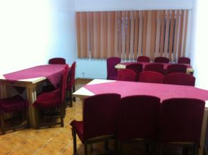 Habitación con mesas rojas y sillas con mantel rosa en Vila Sport Borsec, en Borsec