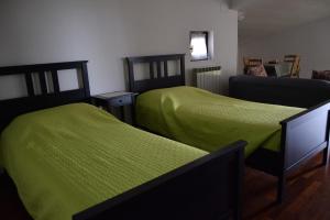 2 letti in una camera con lenzuola verdi di B&B Villa Lodigiana a Brugherio