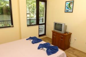 1 dormitorio con cama y vestidor con TV en Complex Sozopol Dreams BMT, en Sozopol