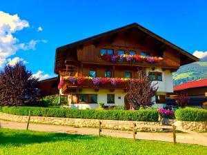 a house with flowers on the side of it at Ferienwohnungen Luxner in Fügen +19 photos
