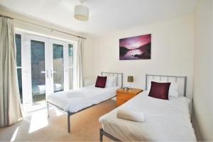 a bedroom with two beds and a window at Spacious 2-Bedroom Apartment with Parking in Windsor 4LA by Accommodation Windsor in Windsor