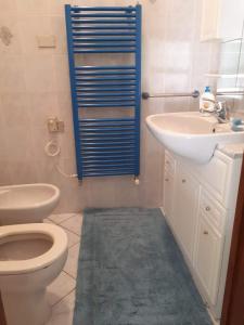 een badkamer met een toilet, een wastafel en een spiegel bij appartamento vicino al mare Alassio in Alassio