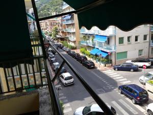 een raam met uitzicht op een straat met auto's bij appartamento vicino al mare Alassio in Alassio