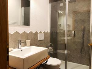 a bathroom with a sink and a toilet and a shower at Villa Giardino - Flowers in Molveno