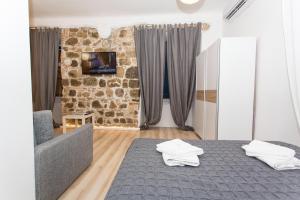 ein Schlafzimmer mit einem Bett und einer Steinmauer in der Unterkunft Apartment Stara vrata in Rijeka