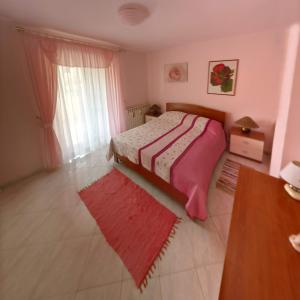 a bedroom with a bed and a table and a window at Anica Apartment in Banjole
