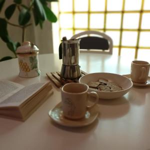a table with a cup of coffee and a plate of cookies at Anica Apartment in Banjole