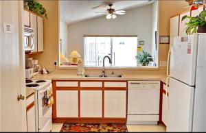 a kitchen with a sink and a white refrigerator at Pool Home 15 Minutes From Disney in Davenport