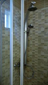 a shower with a shower head in a bathroom at La Mia Casa Vendégház in Kaposvár