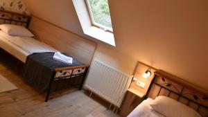a small bedroom with two beds and a window at La Mia Casa Vendégház in Kaposvár