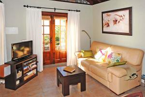 uma sala de estar com um sofá e uma televisão em Casa Ceferino em Tijarafe