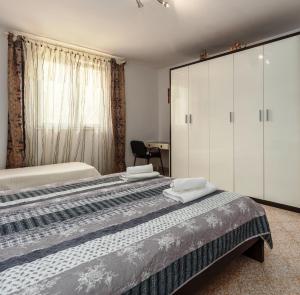 a bedroom with a large bed with white cabinets at Apartment Macan in Bale