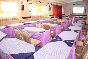 Zimmer mit lila und weißen Tischen und Stühlen in der Unterkunft Hotel Marvin in Nakuru