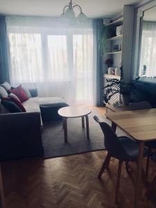 sala de estar con sofá y mesa en Apartament Telimena, en Olsztyn