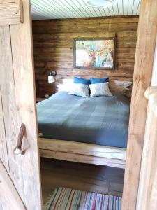 1 dormitorio con 1 cama en una cabaña de madera en Ferienwohnung Woid Mandl en Velden am Wörthersee