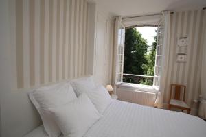 a bedroom with a white bed and a window at Manoir Le Mesnil in Saint-Martin-aux-Chartrains