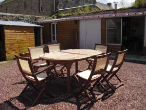 a wooden table with six chairs around it at Vacances à Réthoville in Réthôville