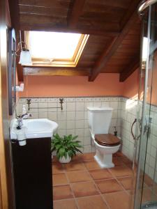 a bathroom with a toilet and a sink and a window at Casas Cuncheiro in Canduas +146 photos