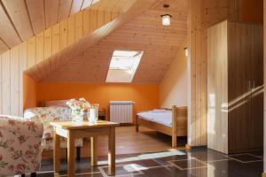 a attic room with a bed and a table at Dworek Zyskowskiego in Danowskie