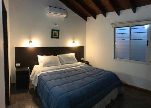 Hostería Boutique El Puente Adults Only في ميرلو: غرفة نوم بسرير كبير ونافذة +97 صورة