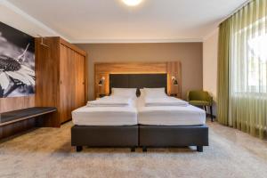 a bedroom with two beds and a large window at Hotel Restaurant Sonne in Gengenbach