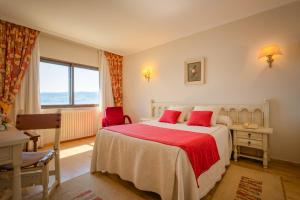 a bedroom with a large bed with red pillows at Hotel Stellamaris in Combarro