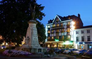 una estatua frente a un edificio con un edificio en Hôtel-Restaurant L'Auberge en Spa