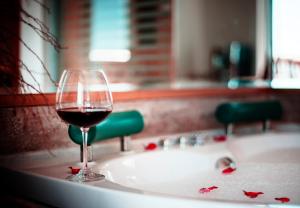 a glass of wine sitting on top of a bath tub at Nur Hotel in Kaş