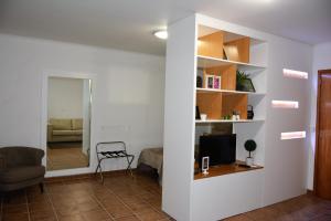 een woonkamer met een bank en een televisie bij Vila Mar in Vila Franca do Campo