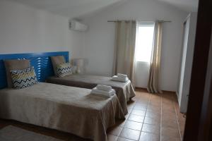 ein Zimmer mit zwei Betten und einem Fenster in der Unterkunft Vila Mar in Vila Franca do Campo