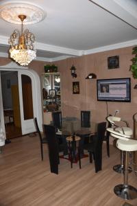 comedor con mesa, sillas y lámpara de araña en 3 Room Flat in Tbilisi en Tiflis