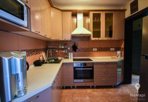 a kitchen with wooden cabinets and a stove top oven at Apartment M&M in Sveti Stefan