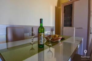 a bottle of wine sitting on a table with two glasses at Apartment M&M in Sveti Stefan