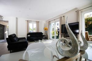 una sala de estar con una mesa de cristal con una escultura en villa Evian Neuvecelle, en Neuvecelle
