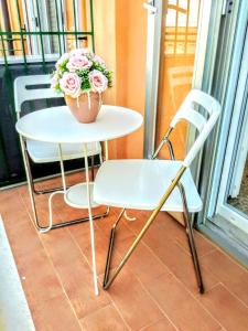 une table et une chaise blanches avec une plante en pot dans l'établissement Dimora Mastcarrir, à Monte SantʼAngelo