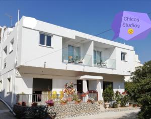een wit huis met een paars bord waarop chiusos studio's staan bij Chicos Studios in Ayia Napa