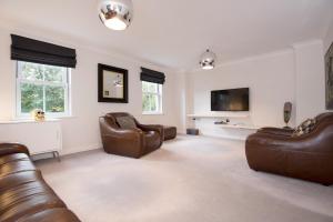 a living room with leather furniture and a flat screen tv at Dalton Crescent in Durham