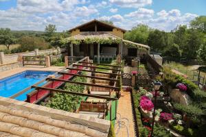 a house with a garden and a swimming pool at La Garrocha in Colmenar del Arroyo