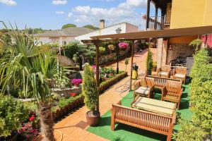 an outdoor patio with benches and flowers and plants at La Garrocha in Colmenar del Arroyo