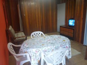 a dining room with a table and chairs and a television at Apartamento Dois in Caxias do Sul