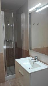 uma casa de banho com um lavatório e um chuveiro com um espelho. em Apartamento Las Tortugas em Arroyo Frío