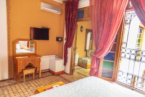 een slaapkamer met een bed en een spiegel bij Riad Tahra & Spa in Fès