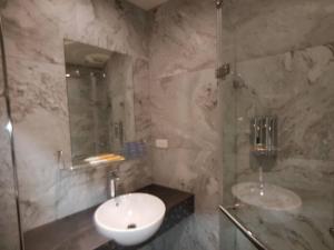 uma casa de banho em mármore com um lavatório e um chuveiro em NingXiaYah Stay em Taipei