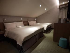 a hotel room with two beds in a room at NingXiaYah Stay in Taipei