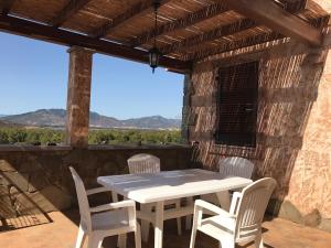 a table and chairs on a patio with a view at Villino Aurora in Villaputzu